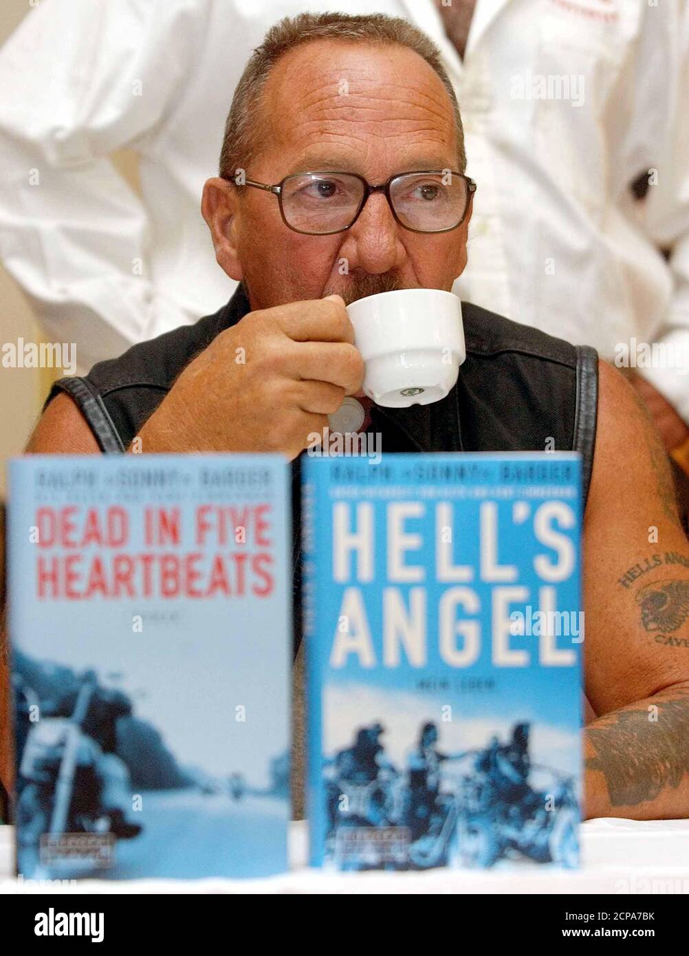 Legendary Hell's Angel Ralph 'Sonny' Barger drinks a cup of coffee during a news conference in Vienna September 3, 2003. Barger, who has spent more than 40 years as a member of the most infamous motorcycle club in the world and was its de facto leader during the 1960s and 1970s, is promoting his new book 'Dead in five heartbeats', his first novel following two documentary Hell's Angels books. REUTERS/Heinz-Peter Bader  HPB/ Stock Photo