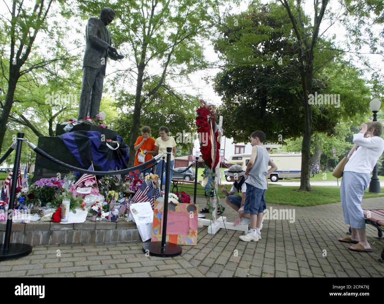 Mourners suvey a memorial to U.S. President Reagan at his boyhood home in Dixon, Illinois, June 7, 2004. Reagan died at his Los Angeles home June 5 at the age of 93 and had left wishes that regular Americans would be able to pay tribute to him. REUTERS/John Gress  JG Stock Photo