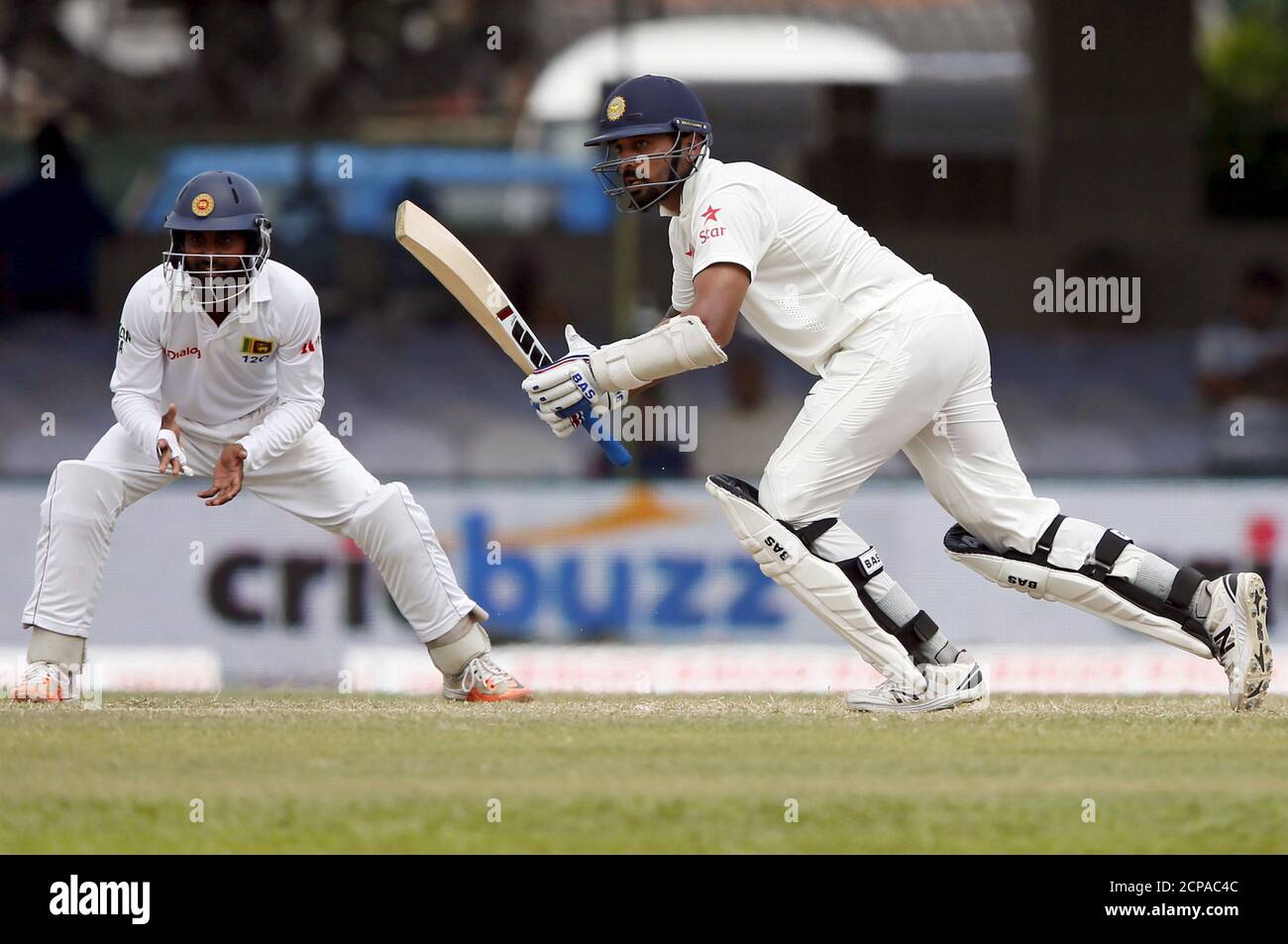 India's Murali Vijay (R) watches his shot next to Sri Lanka's Kaushal Silva on the fourth day of their second test cricket match in Colombo August 23, 2015. REUTERS/Dinuka Liyanawatte Stock Photo