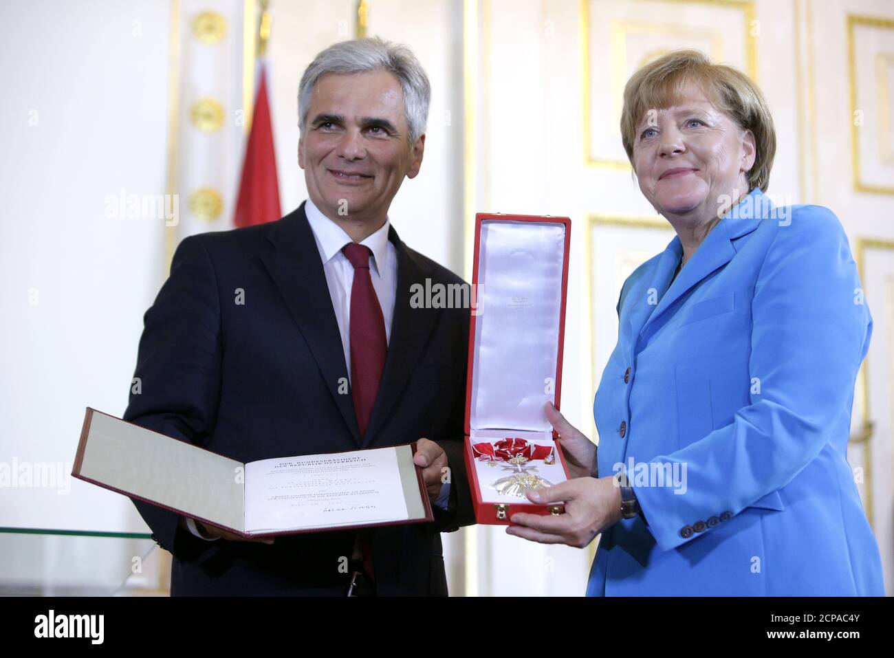 German Chancellor Angela Merkel receives the Golden Decoration of Honour for Services to the Republic of Austria from Austrian Chancellor Werner Faymann during the Western Balkans Summit in Vienna August 27, 2015.   REUTERS/Lisi Niesner Stock Photo