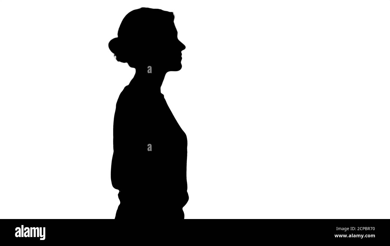 Silhouette Young beautiful girl with hands in pockets walking Stock ...