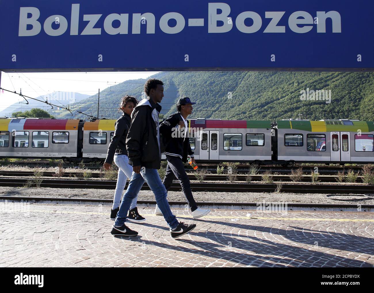 Dejen Asefaw (R), a 24-year-old Eritrean, arrives at the Bolzano railway station, northern Italy, May 28, 2015. EU asylum rules, known as the Dublin Regulation, were first drafted in the early 1990s and require people seeking refuge to do so in the European country where they first set foot. Northern European countries defend the policy as a way to prevent multiple applications across the continent. Some are upset with what they see as Italy's lax attitude to registering asylum seekers. Earlier this year, French police stopped about 1,000 migrants near the border and returned them to Italy. Sm Stock Photo