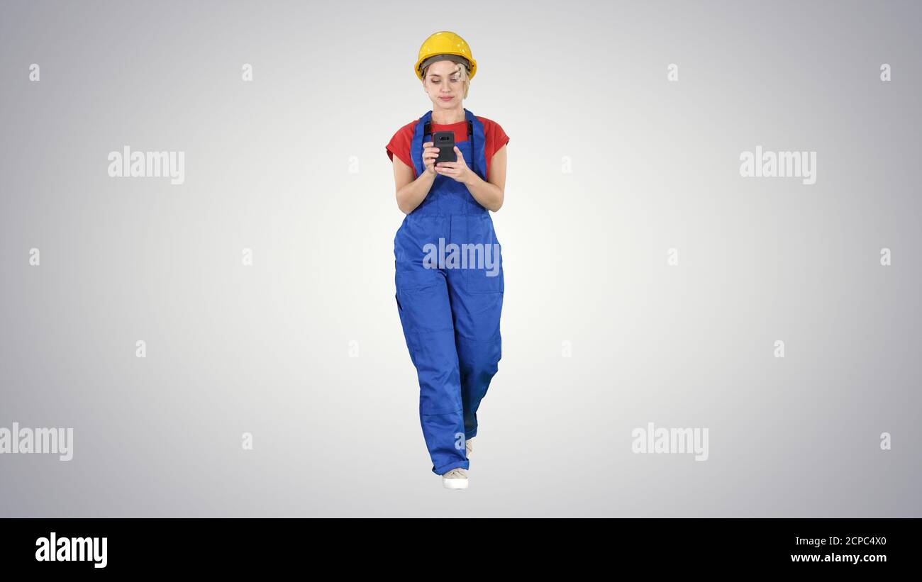 Female worker walking and using phone on gradient background. Stock Photo