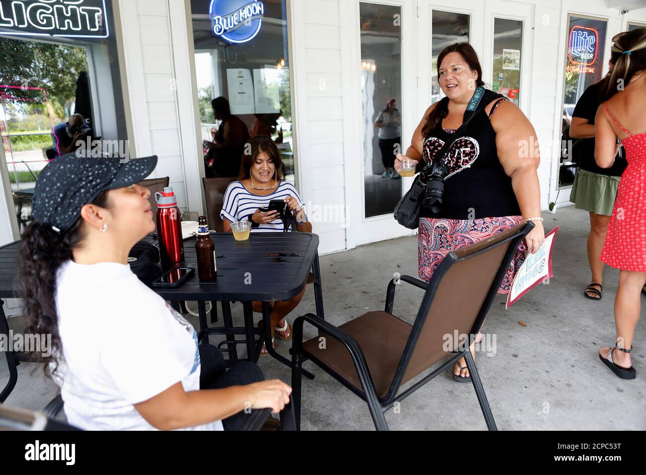 Tara Hill (R) talks with her supporters during the reopen Florida 'maskless' rally and dinner held at 33 & Melt restaurant to protest mandatory face mask restrictions during the coronavirus disease (COVID-19) pandemic in Windermere, Florida, U.S. July 11, 2020. REUTERS/Octavio Jones Stock Photo