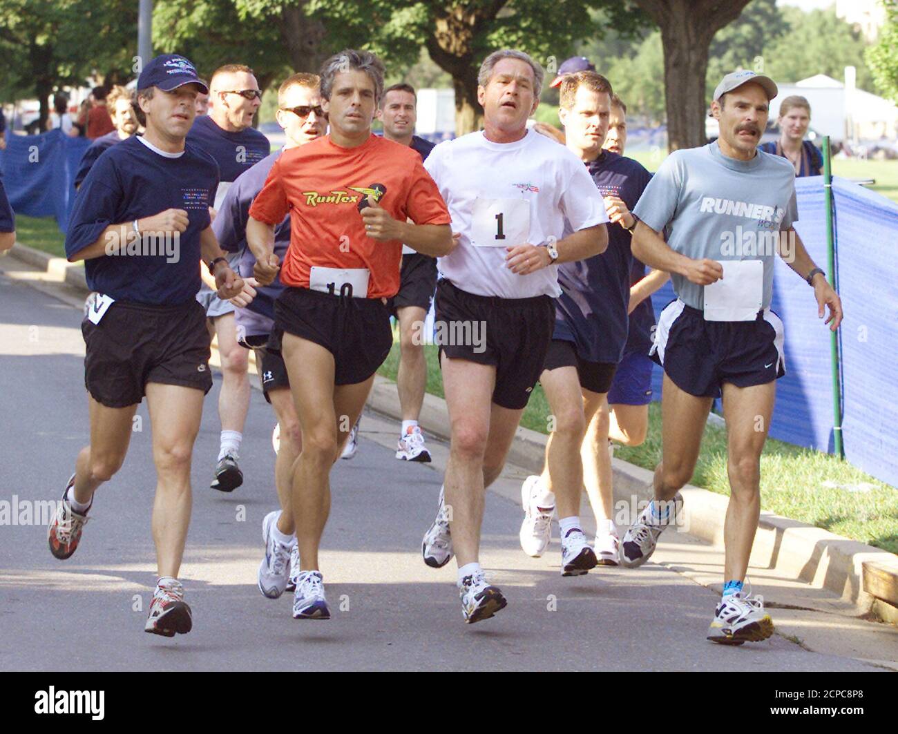 U.S. President George W. Bush (1) runs in The President's Fitness Challenge, a three-mile run at Fort McNair in Washington, June 22, 2002. Bush finished the run at 20 minutes and 28 seconds. The president unveiled his HealthierUS initiative on Thursday which calls for at least a half-hour of exercise every day for adults and more for children, eating smaller portions of more nutritious foods, regular preventative health screenings and avoidance of any risky behaviors, especially involving alcohol, tobacco and illegal drugs. REUTERS/Hyungwon Kang  HK Stock Photo