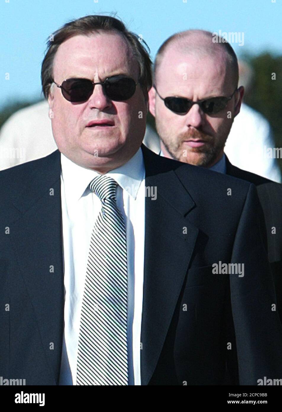 Britain's Deputy Prime Minister John Prescott (L) wears sunglasses as he walks with an aide in the early morning sunshine on the second day of the Labour Party conference in Bournemouth, September 29, 2003. REUTERS/Stephen Hird  RUS/ASA Stock Photo