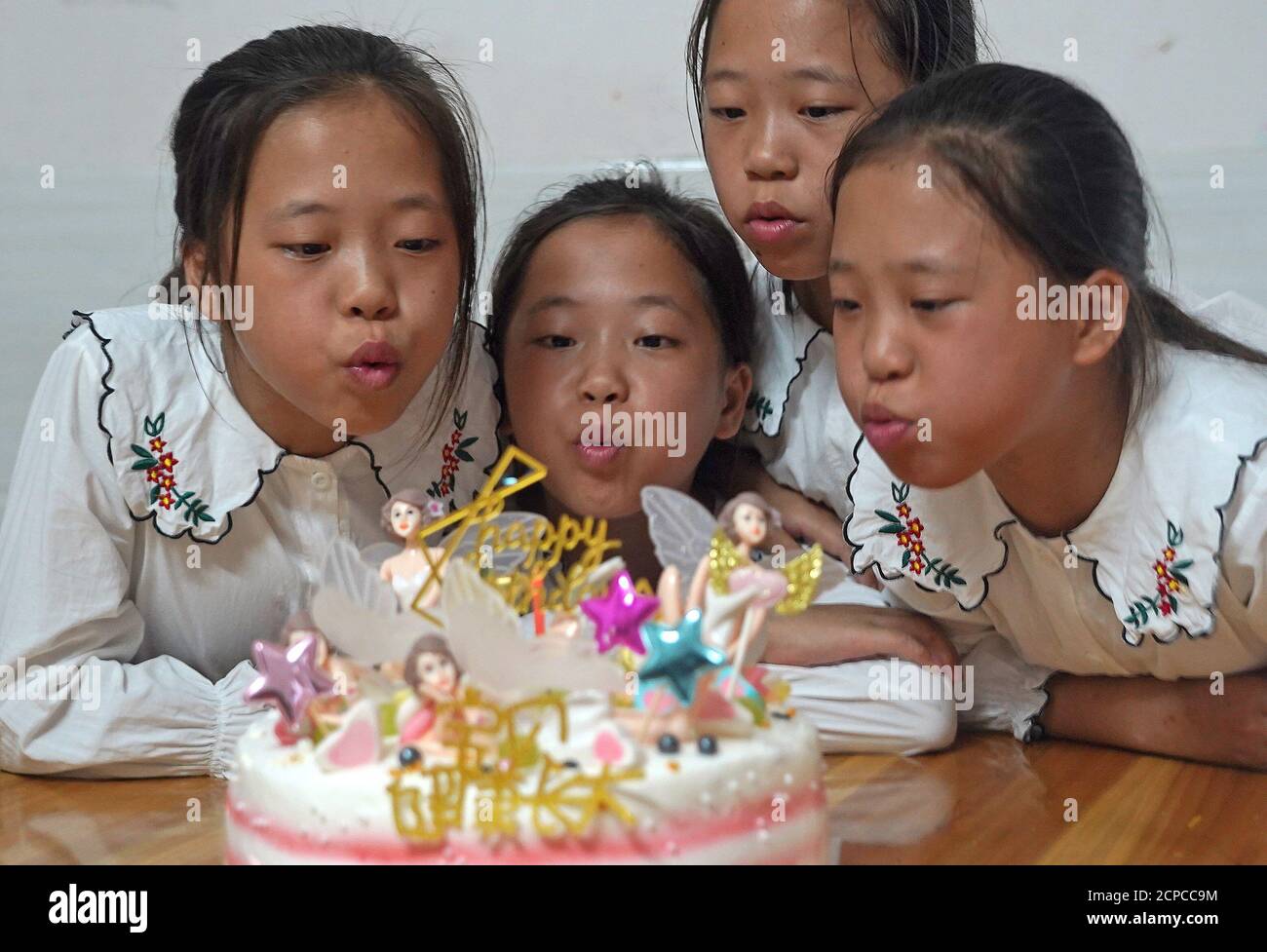 (200919) -- GANZHOU, Sept. 19, 2020 (Xinhua) -- The quadruplet girls celebrate their birthday at their new house in Shangbao Village, Ganzhou City of east China's Jiangxi Province, Sept. 10, 2020. Wu Nianyou, a farmer in Shangbao Village of Ganzhou City, and his wife saw their quadruplet daughters come to the world on a morning in September 2010. They named their daughters Wu Mengling, Wu Mengting, Wu Mengyun and Wu Mengqin, who became their worry to raise up with little income only from the fields. Being premature babies, the girls were in poor health conditions which needed lots of money to Stock Photo