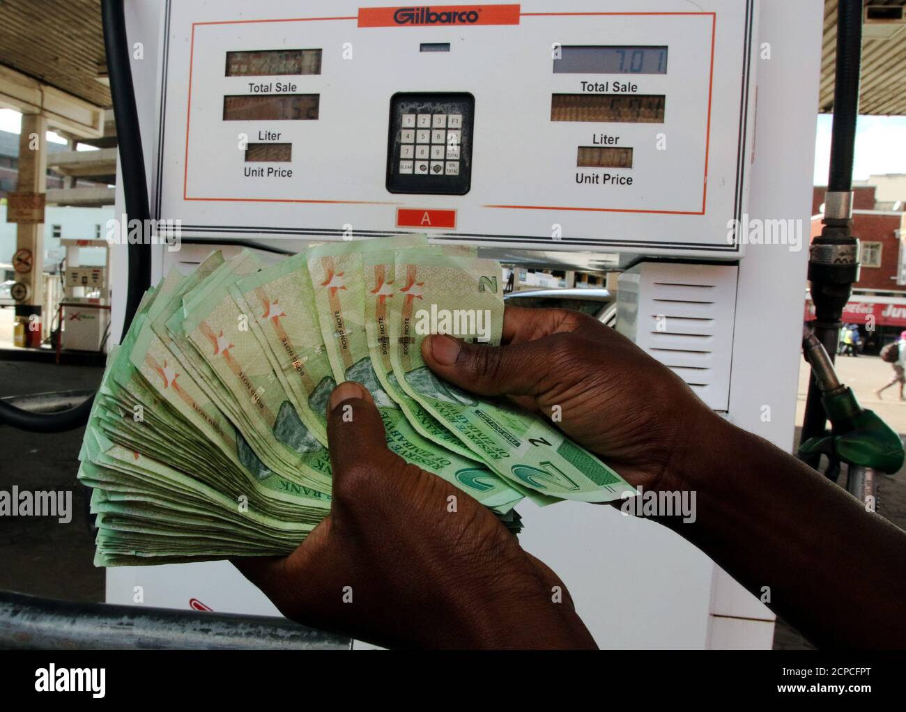 A petrol pump attendant counts new bond notes at a fuel station in