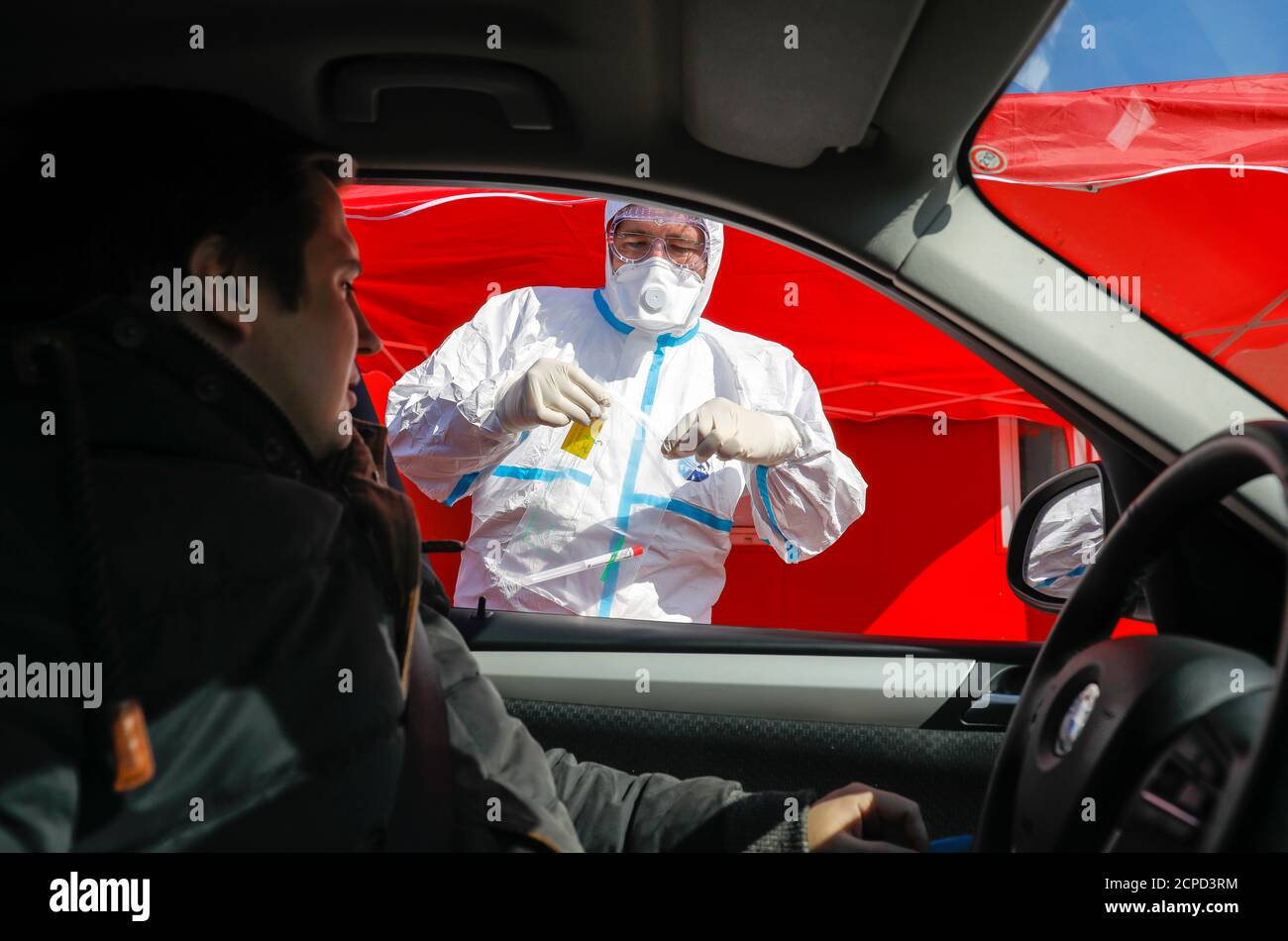 Drive-in for corona virus test, at the mobile test station a doctor takes a smear through the car window (posed scene), Kempen, Lower Rhine, North Stock Photo