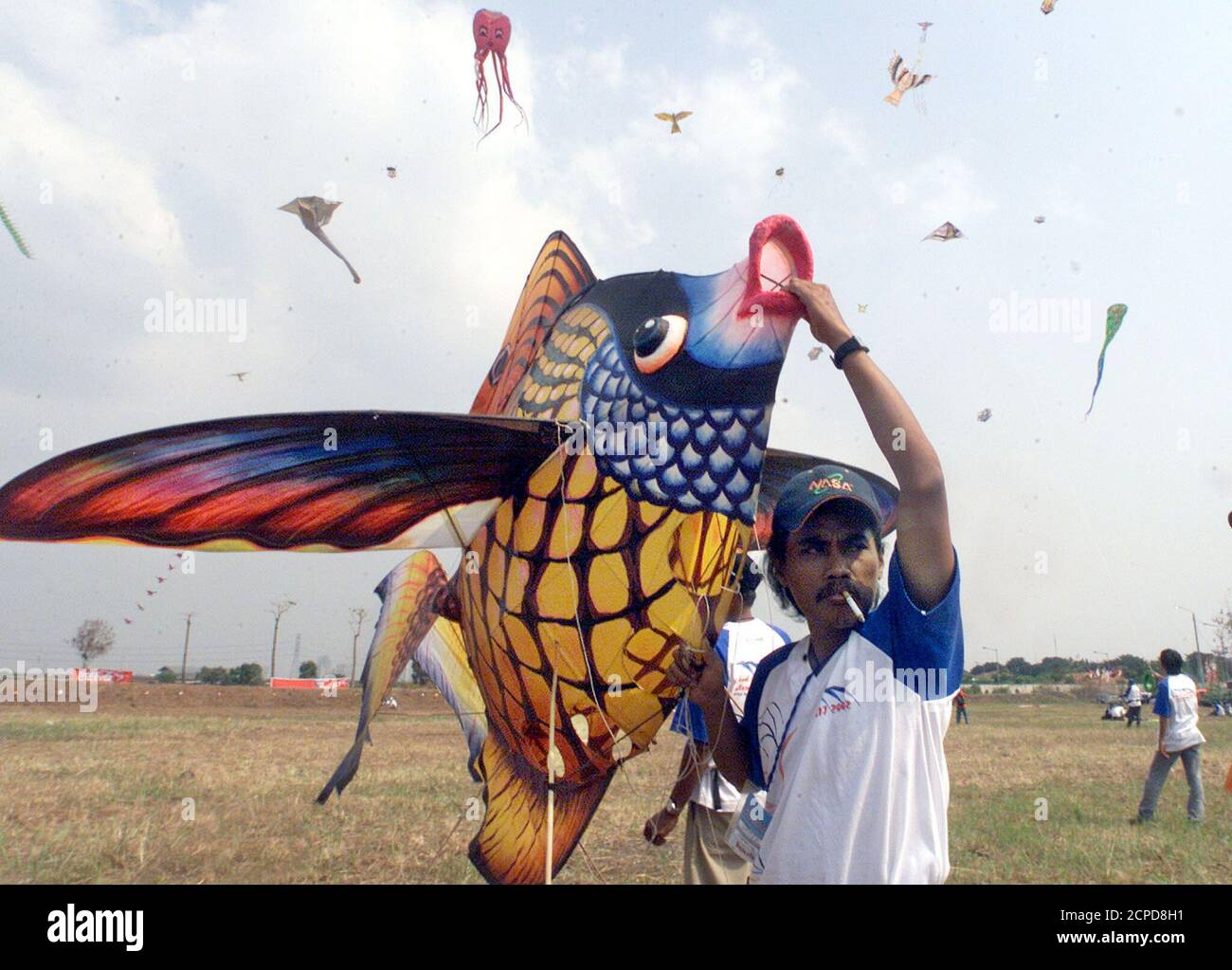 An Indonesian participant prepares to fly a kite shaped like a fish in Jakarta June 30, 2002. The men are among dozens of international participants at Jakarta's international kite festival. Eleven countries and dozens of provinces in Indonesia will take part in the three-day festival. REUTERS/Supri AS/DL Stock Photo