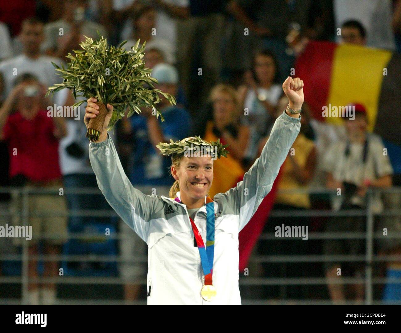 Gold medallist Belgiums Henin-Hardenne waves from the podium after the ceremony for the women's single tennis event of Athens 2004 Olympic Games.  Gold medallist Belgium's Justine Henin-Hardenne waves from the podium after the ceremony for the women's single tennis event of Athens 2004 Olympic Games August 21, 2004. France's Amelie Mauresmo won silver medal and Australia's Alicia Molik won bronze medal. REUTERS/Carlos Barria Stock Photo