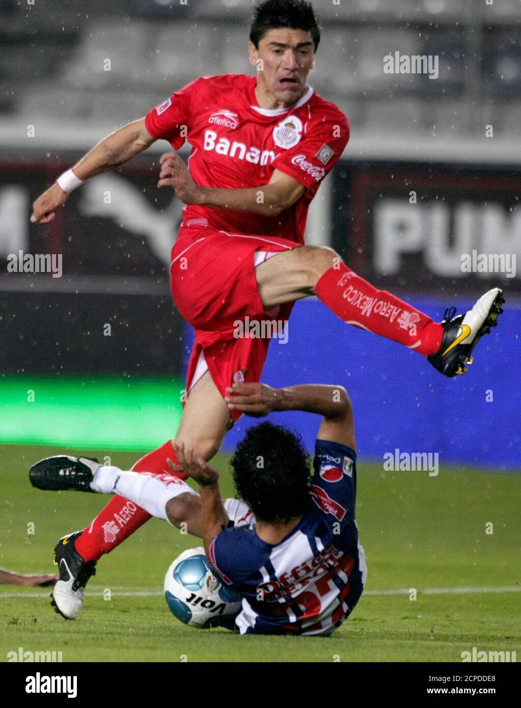 Pachuca midfielder Edy Brambila (bottom) battles for the ball against Toluca striker Hector Mancilla (top) of Paraguay during their Mexican league championship soccer match in Hidalgo stadium in Pachuca City, Mexico, April 17, 2010. REUTERS/Henry Romero (MEXICO - Tags: SPORT SOCCER) Stock Photo