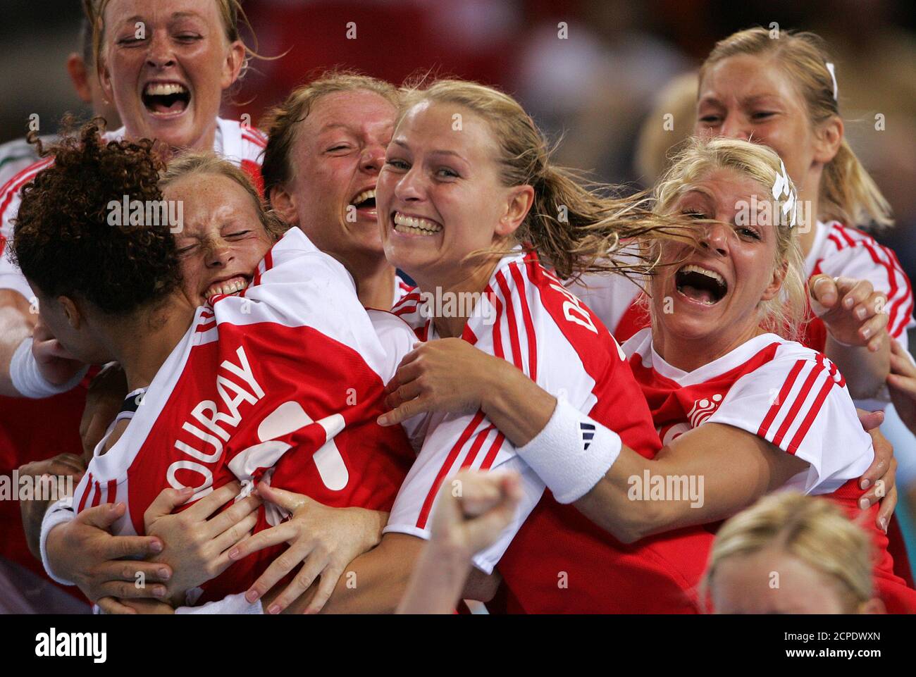 Denmark's Olympic champions Line Daugaard (C) and Rikke Hoerlykke  Joergensen (R) celebrate their gold medal win after they defeated South  Korea in the women's handball finals match at the Athens 2004 Olympic