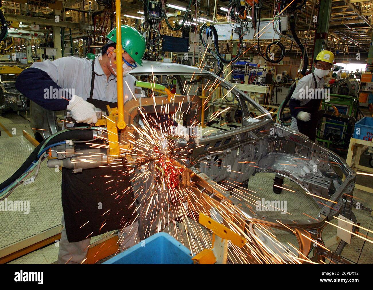An Indonesian worker welds a part of a new multi-purpose vehicle called Kijang Innova at the Toyota plant in Karawang, West Java province on September 1, 2004. Indonesia's leading auto distributor, PT Astra International Tbk, launched a new generation of its best selling car on Wednesday. REUTERS/Beawiharta  BEA/TW Stock Photo
