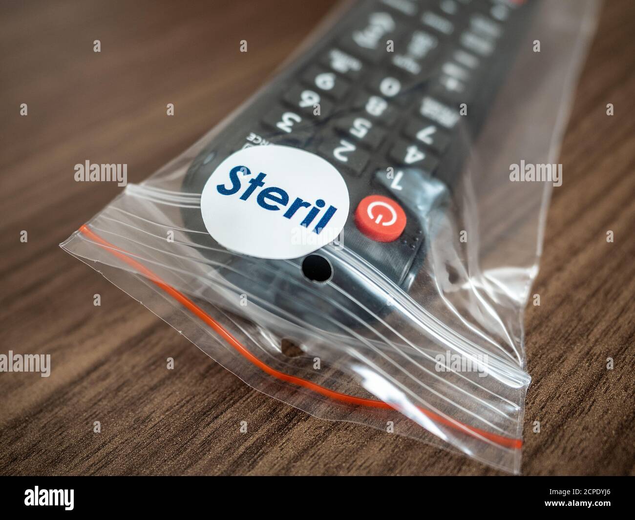 TV remote control in steril bag ready to use in hotel room. COVID-19 protection concept. Stock Photo