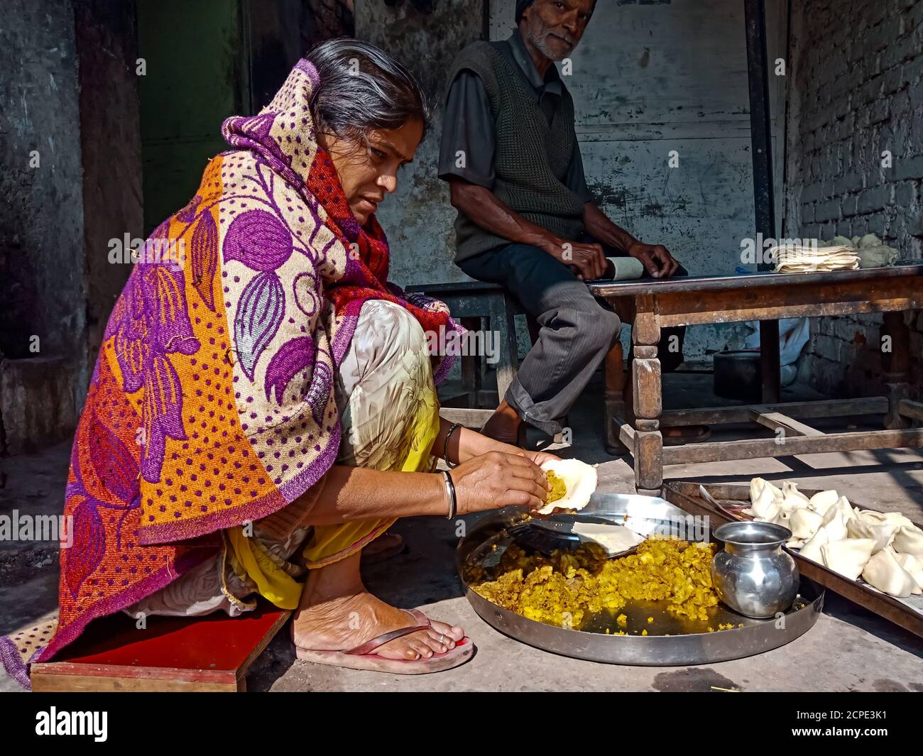 DISTRICT KATNI, INDIA - JANUARY 08, 2020: An indian old lady making samosa in poor hotel. Stock Photo