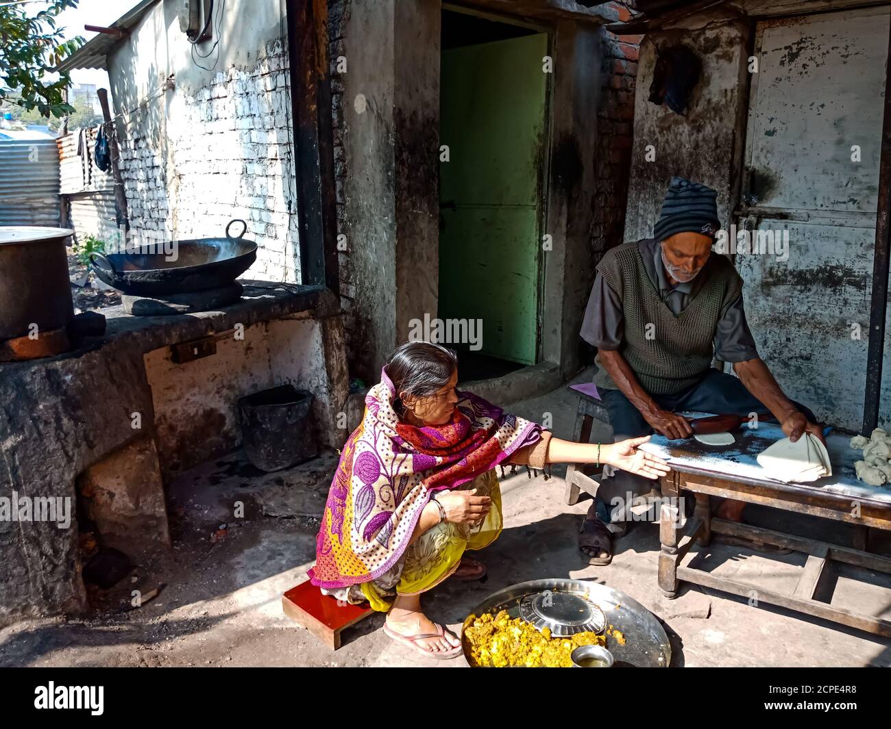 DISTRICT KATNI, INDIA - JANUARY 08, 2020: Two asian old couple making samosa in poor hotel. Stock Photo