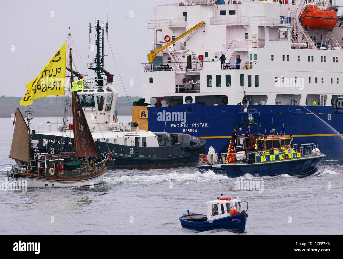 Anti-nuclear protestors and police escort the British Nuclear Fuels (BNFL) ship Pacific Pintail down the Walney channel to Barrow-In-Furness, September 17, 2002. A flotilla of boats led by the flagship Rainbow Warrior of the environmental group Greenpeace circled Pacific Teal and her sister ship Pacific Pintail, both carrying shipments of nuclear waste, as they neared their destination after a controversial two-month journey from Japan. Environmentalists and national governments from New Zealand to Ireland feared the cargo of potentially weapons-usable MOX - mixed uranium and plutonium oxide f Stock Photo