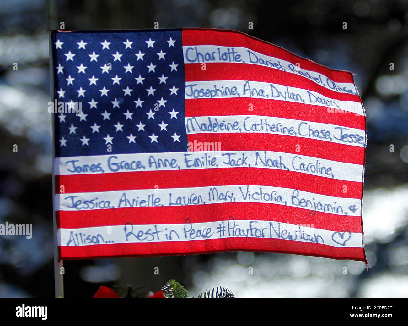 A flag that bears the names of the dead flies over a makeshift memorial in Sandy Hook after the December 14 shooting tragedy when a gunman shot dead 20 students and six adults at Sandy Hook Elementary, in Newtown, Connecticut, December 28, 2012    REUTERS/Carlo Allegri  (UNITED STATES - Tags: CRIME LAW EDUCATION) Stock Photo
