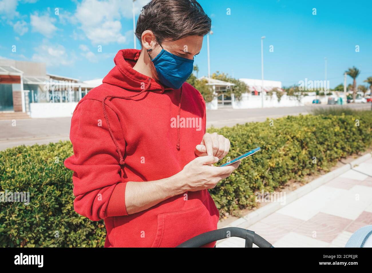 Men using his smartphone with a face mask in Spain Stock Photo Alamy