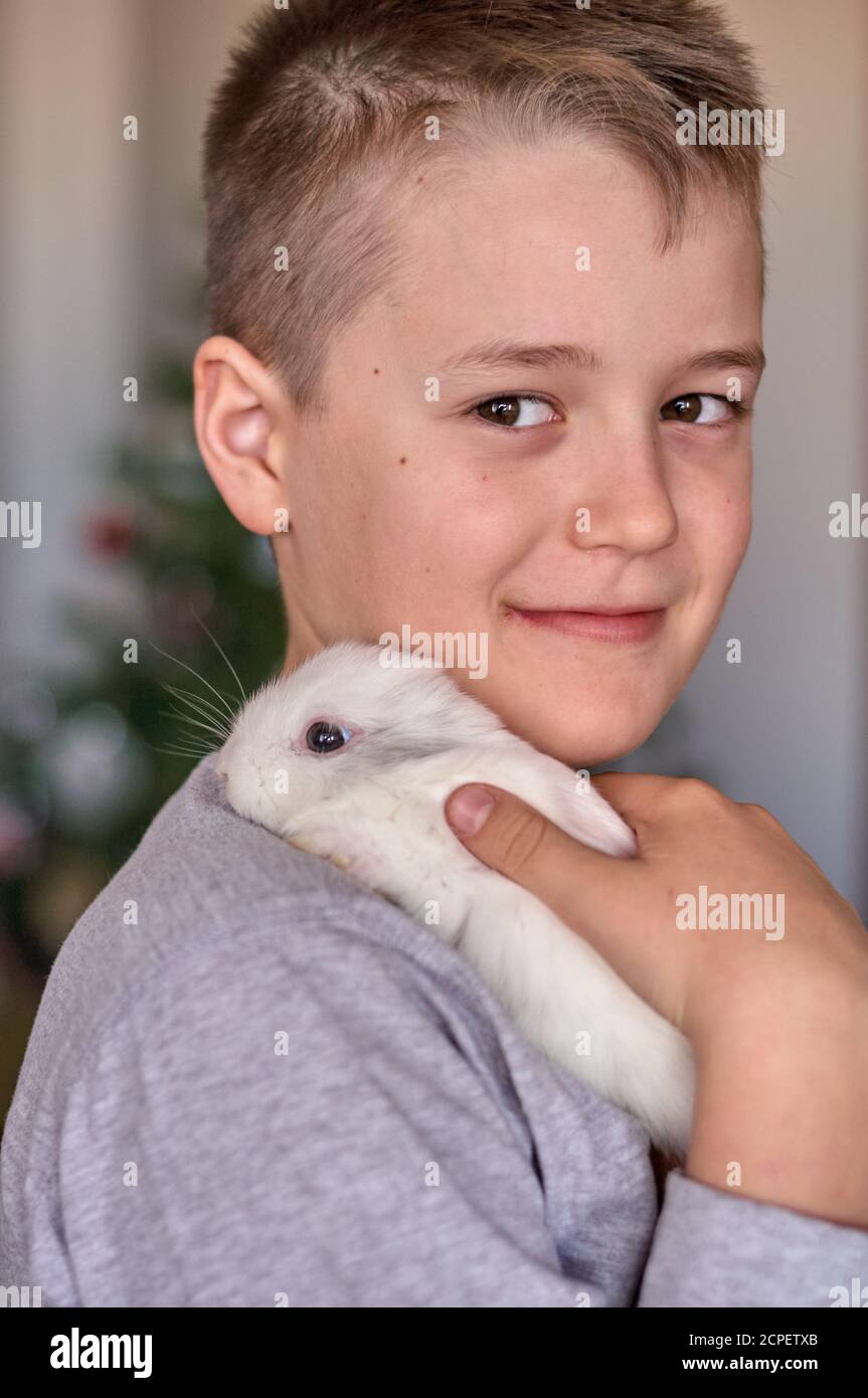 a boy with a white rabbit in his hands Stock Photo Alamy