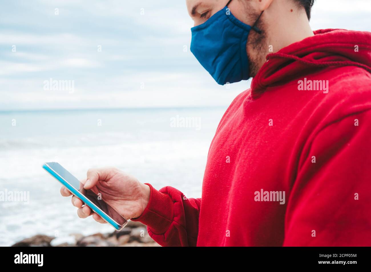 Men using his smartphone with a face mask in Spain Stock Photo Alamy