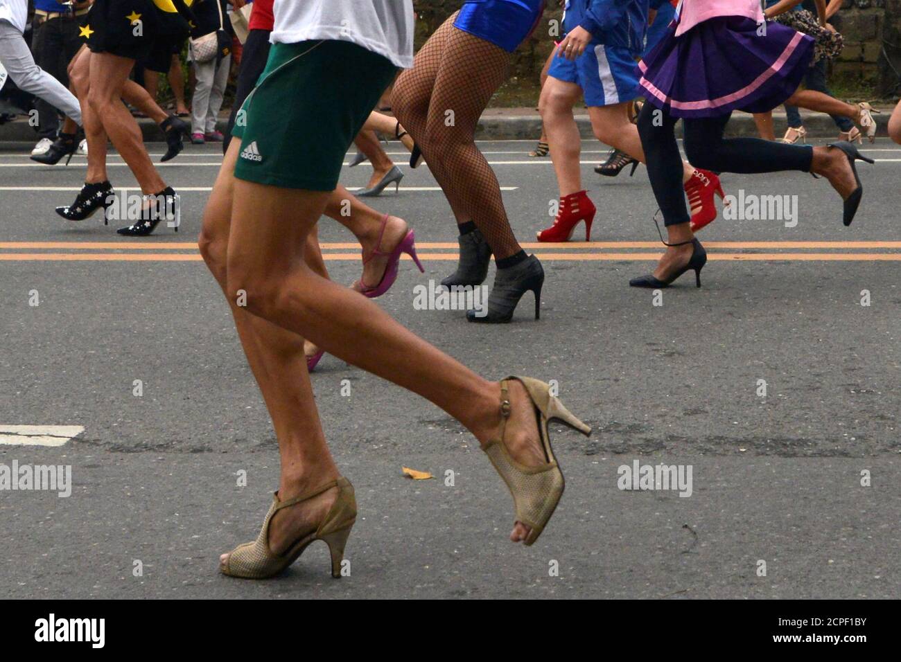 Participants wearing stilettos run as they compete in the "Tour De Takong" stiletto  race, as part of activities for the town's annual shoe festival, along Shoe  Avenue in Marikina city, Metro Manila,