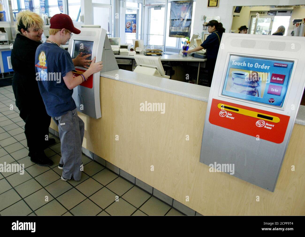 Dominic Archuleta (L) and Brogan Geurts (R) use a computer terminal called a  kiosk to order breakfast at a McDonalds restaurant in the Denver suburb of  Littleton, Colorado July 10, 2003. The