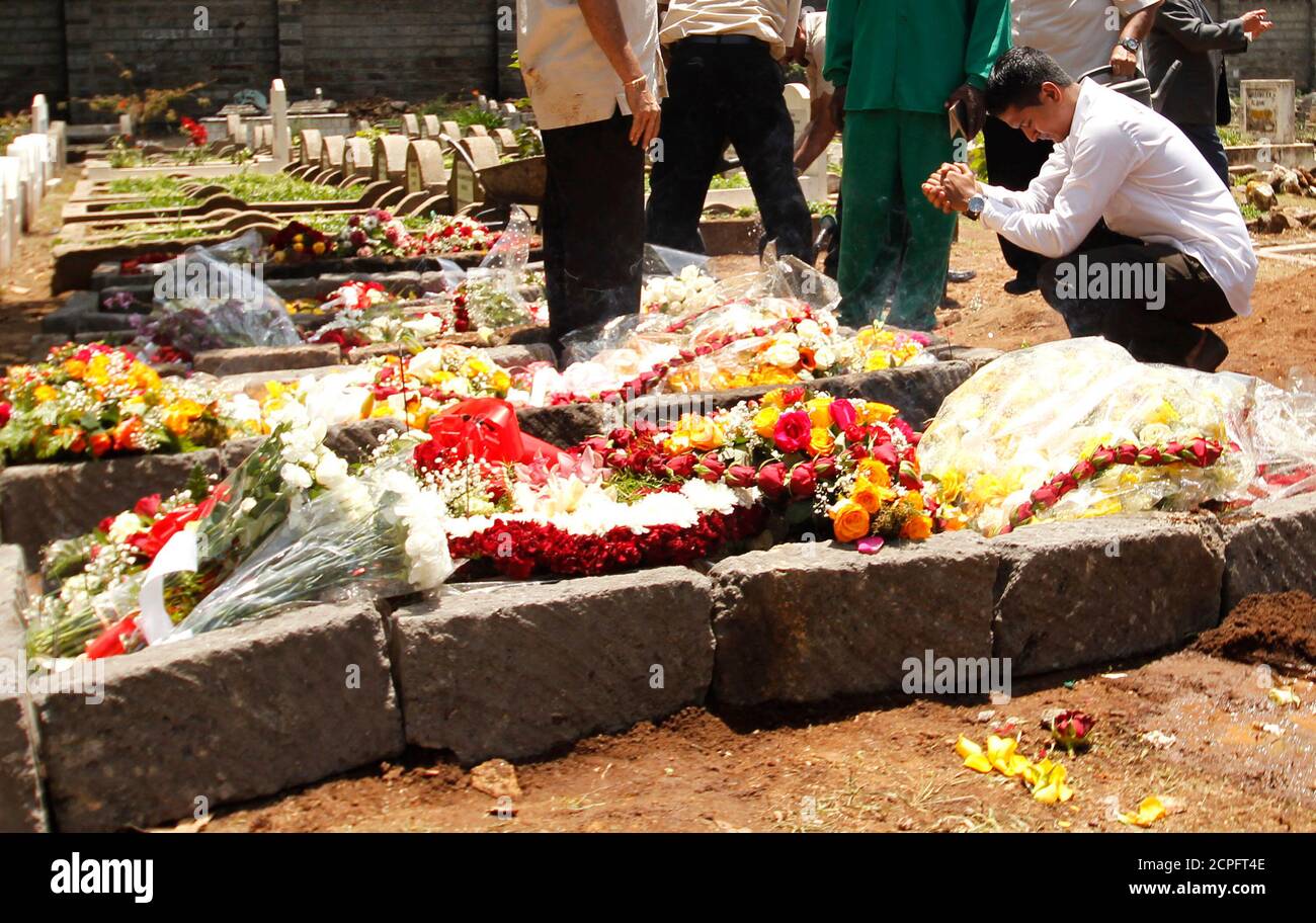 A relative prays at the grave of Kenyan journalist Ruhila Adatia Sood, who was killed in the Westgate shopping mall attack, during her funeral in Kenya's capital Nairobi September 26, 2013. U.S., British and Israeli agencies are helping Kenya investigate the attack claimed by Somali Islamist militants on the Nairobi shopping mall that killed at least 72 people and destroyed part of the complex, officials said on Wednesday.    REUTERS/Thomas Mukoya (KENYA - Tags: CIVIL UNREST CRIME LAW RELIGION) Stock Photo