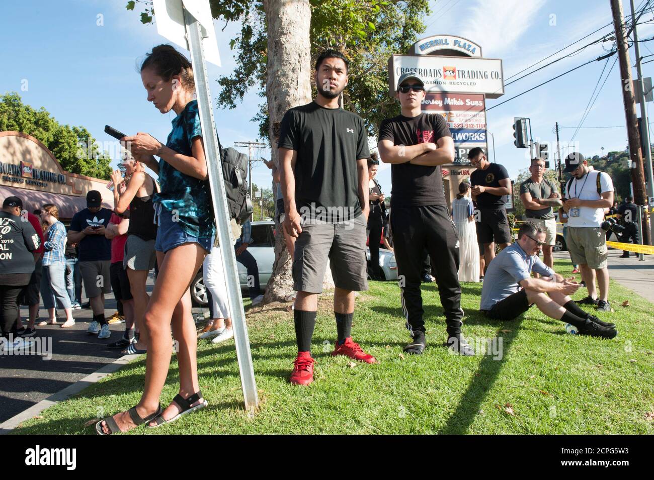 Trader Joe's employees and others wait in a parking lot near a Trader