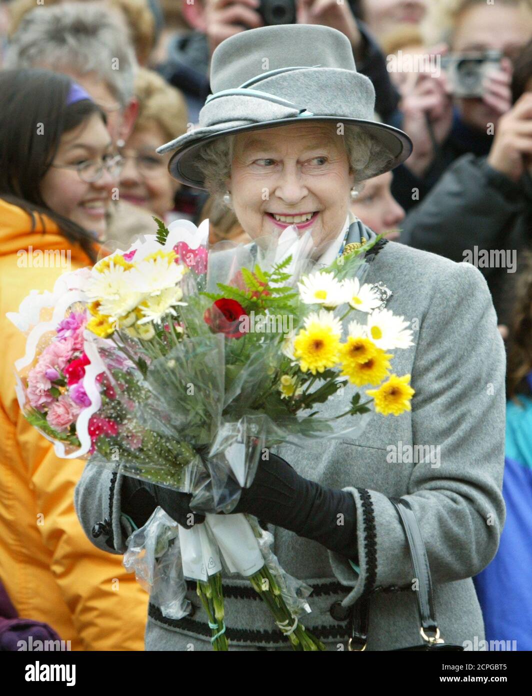 Queen Elizabeth II holds flowers given to her as she tours the Forks Market in Winnipeg, Manitoba, October 8, 2002. The Queen is currently on an 11-day Golden Jubilee tour of Canada. REUTERS/Shaun Best  SB Stock Photo