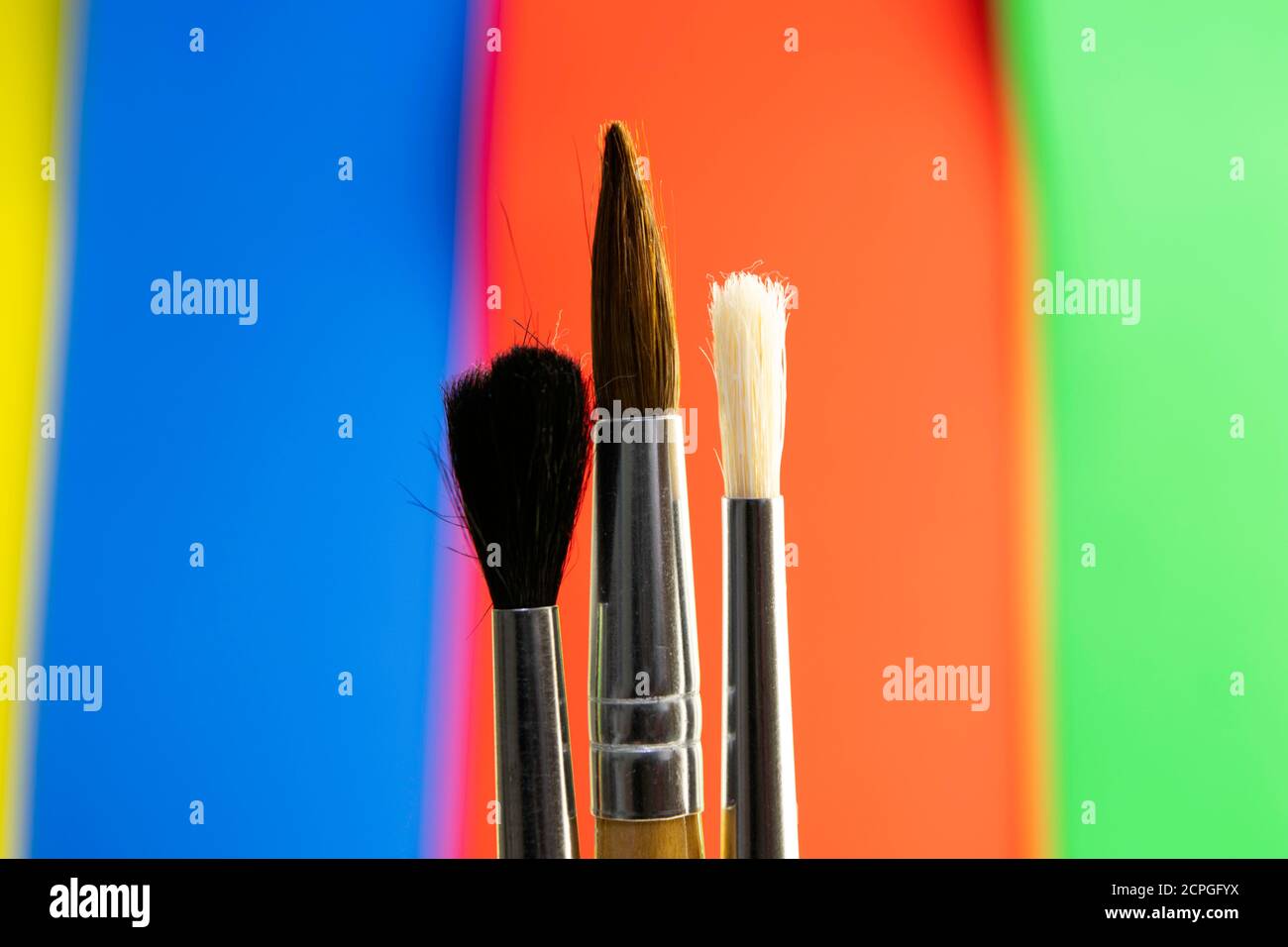 paint brushes on color blurred red-blue-green-yellow background Stock Photo