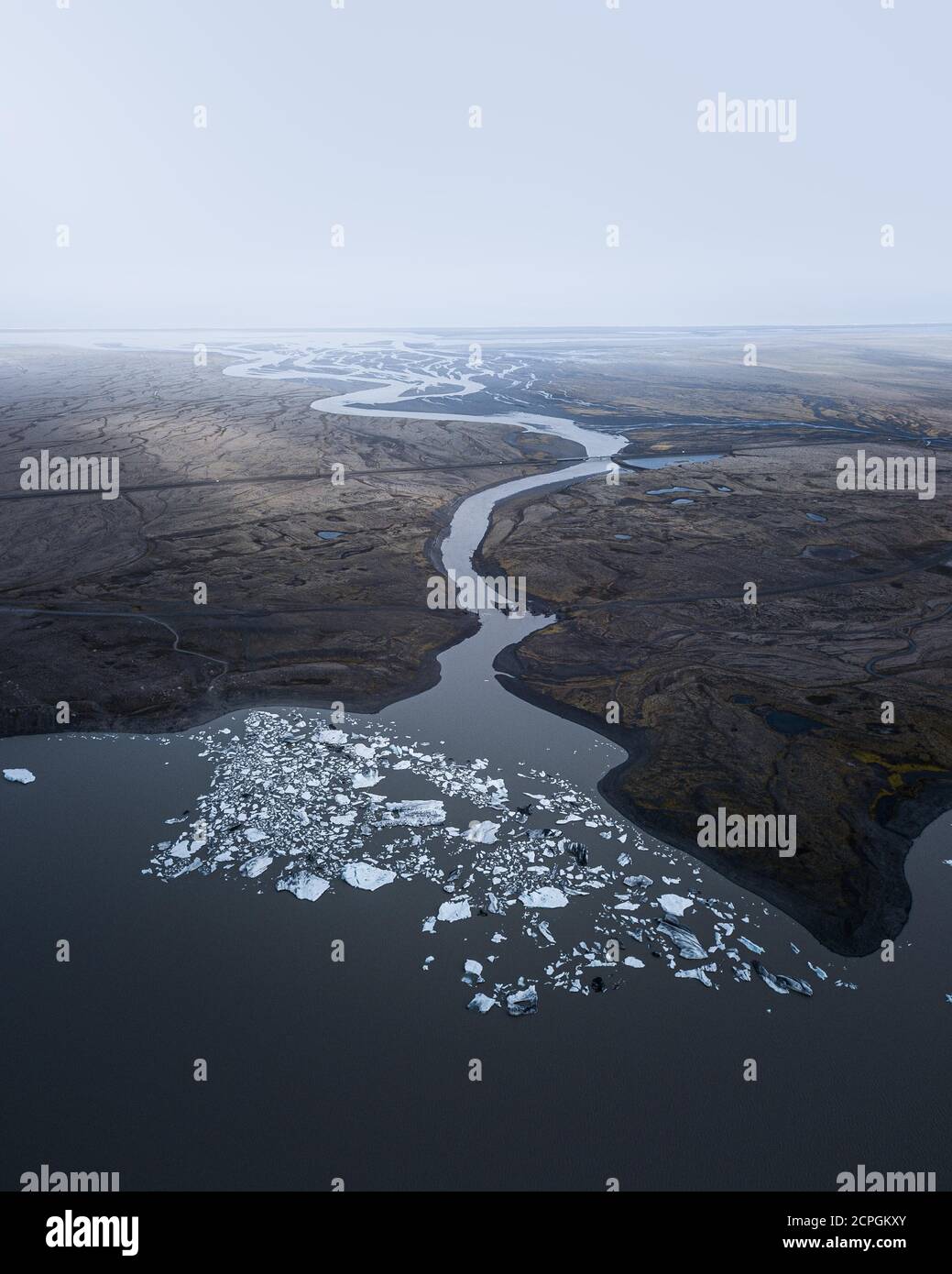 Aerial view, glacial lake with glacial river flowing through volcanic ...
