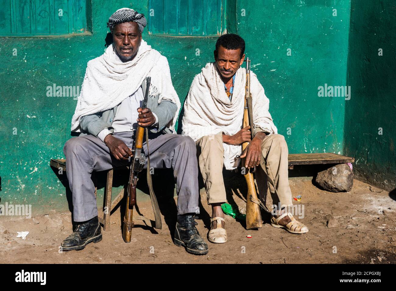 Two sentries with rifles sitting on a bench, Simien Mountains National Park, Ethiopia, Africa Stock Photo