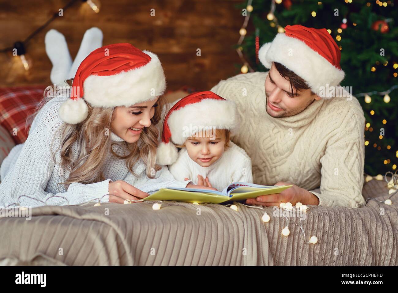 Happy family reading a book at Christmas. Stock Photo
