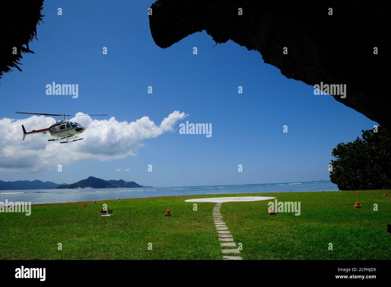 Helicopter landing on a helipad on a tropical island Stock Photo Alamy