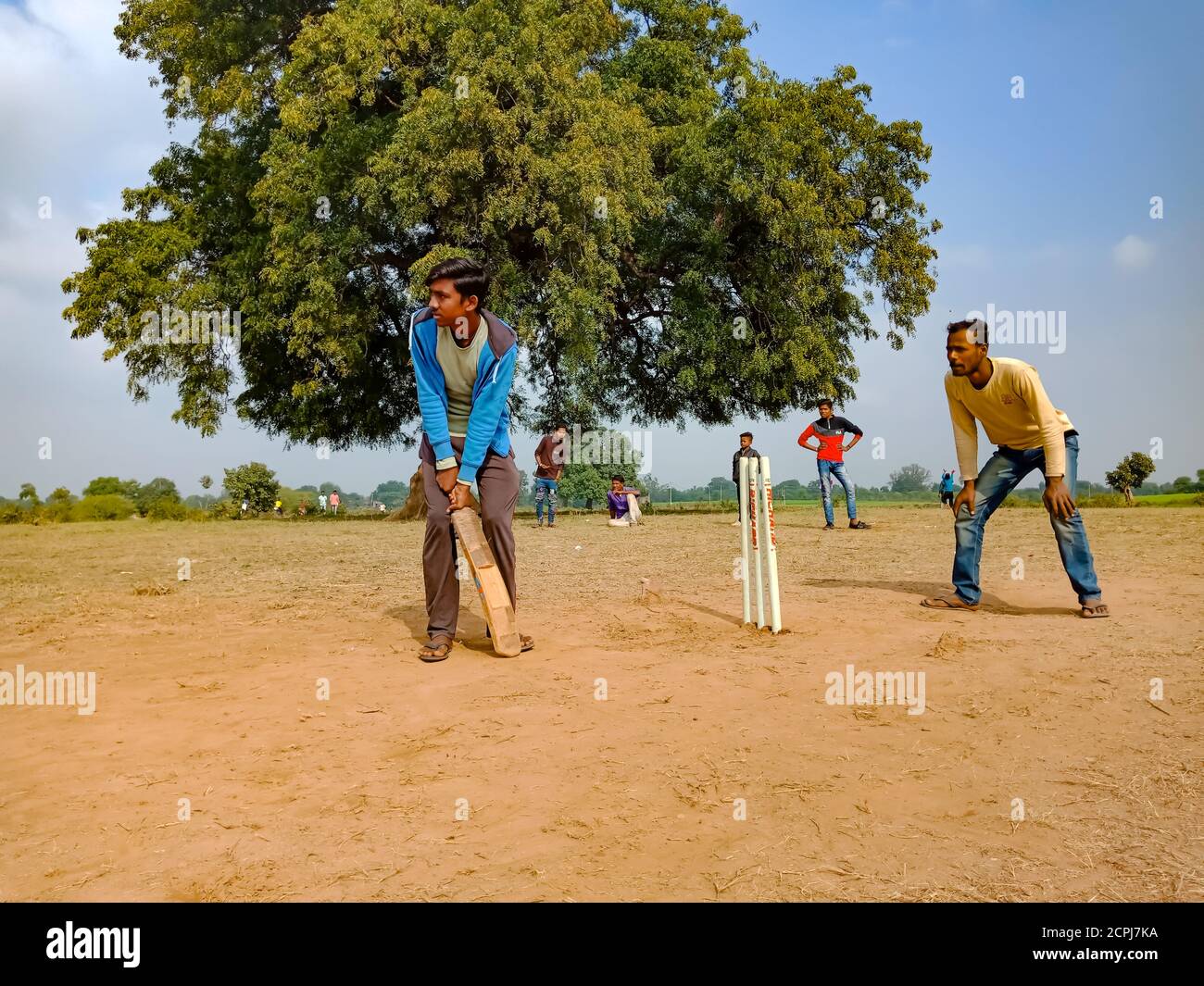 DISTRICT KATNI, INDIA - JANUARY 01, 2020: Asian poor village children groups playing cricket at countryside rural environment. Stock Photo