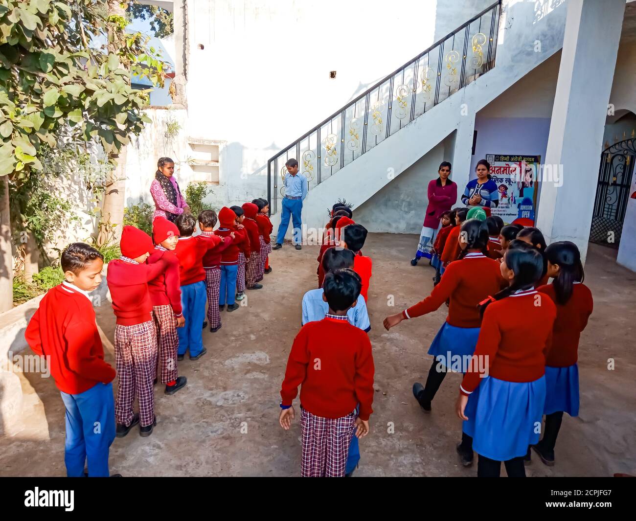 DISTRICT KATNI, INDIA - JANUARY 13, 2020: Indian primary school students group gathering at open background wearing red color uniform. Stock Photo