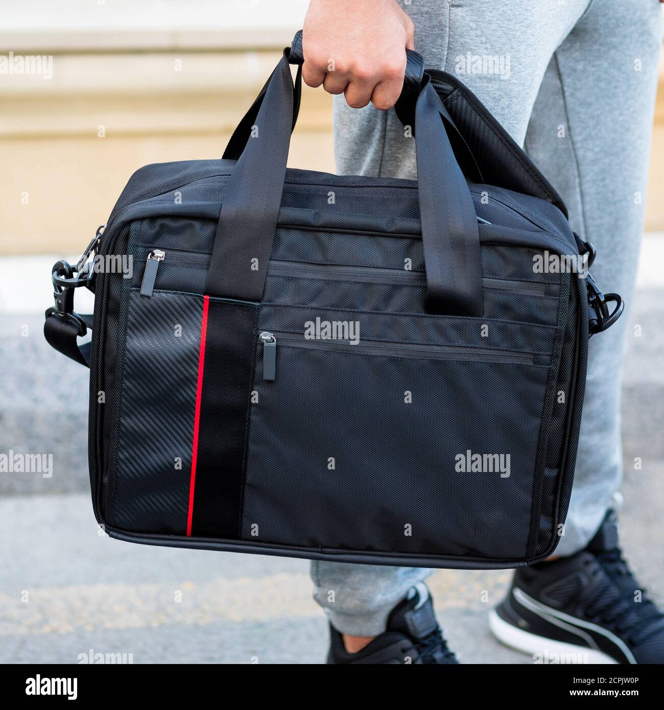 Young man holding a black sport bag close up Stock Photo