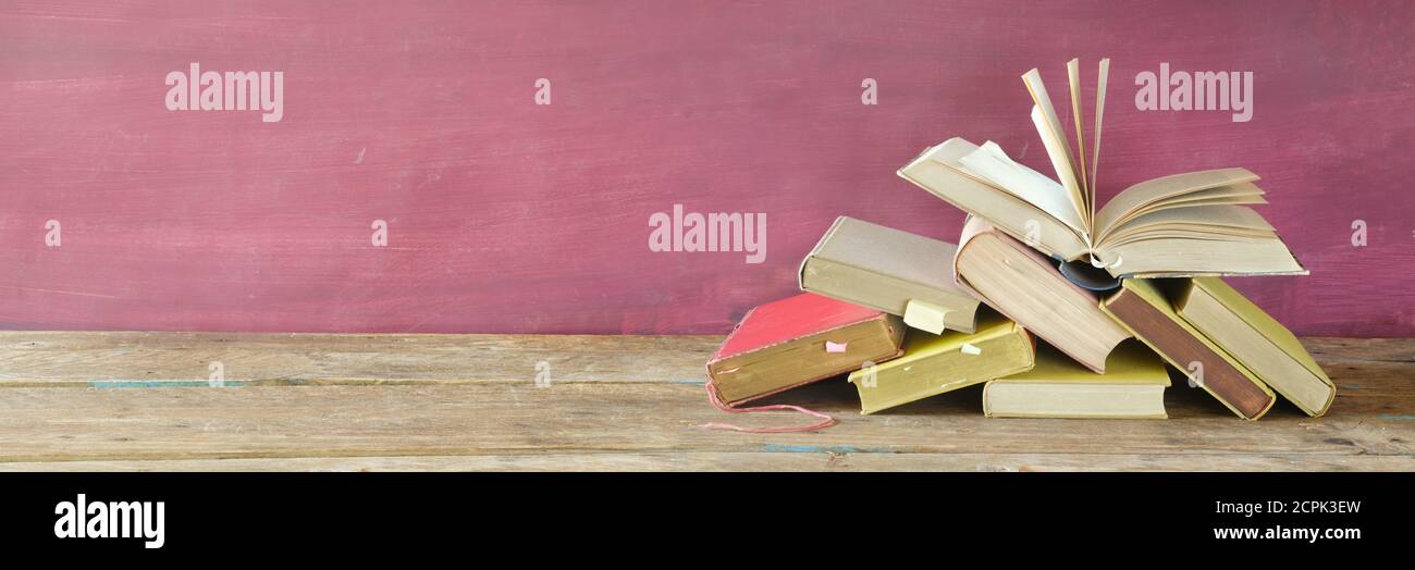 Stack of books and open book. Reading,literature,education,library,home office concept, panoramic large copy space Stock Photo