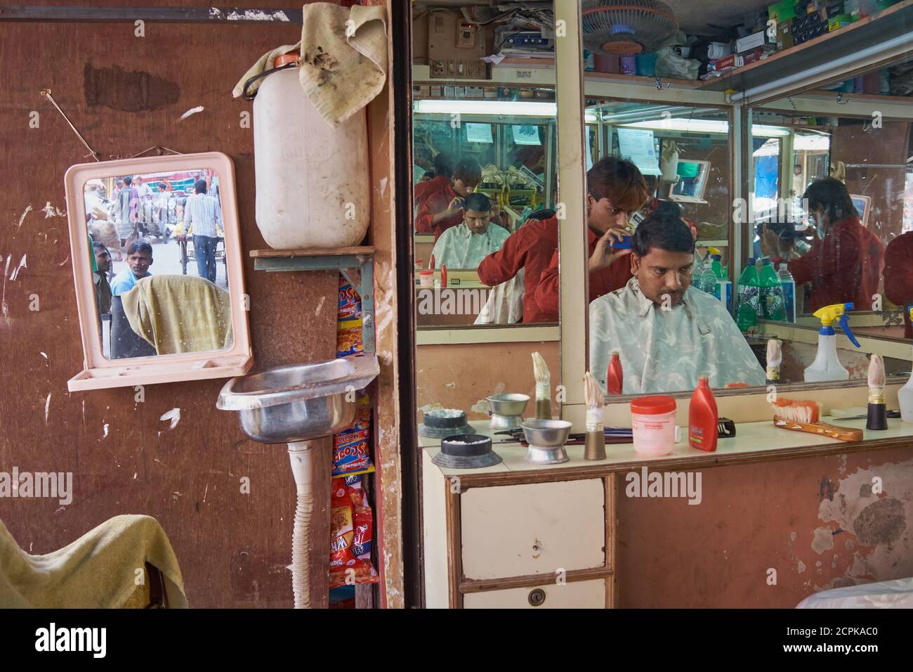 Mirrors at a hairdresser's shop in Mumbai, India, reflect hairdresser