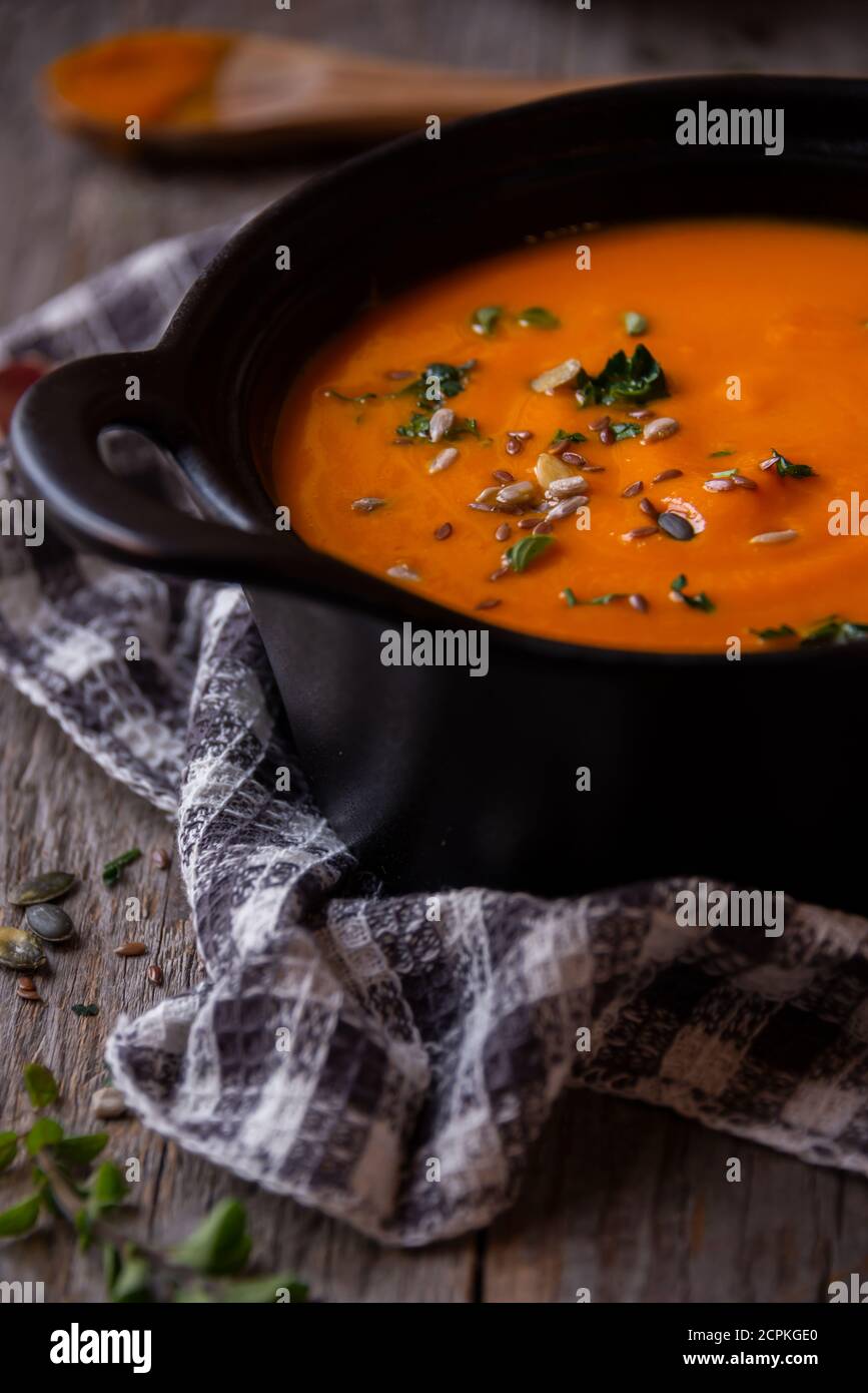 Hot pumpkin soup in cooking pot on dark background Stock Photo