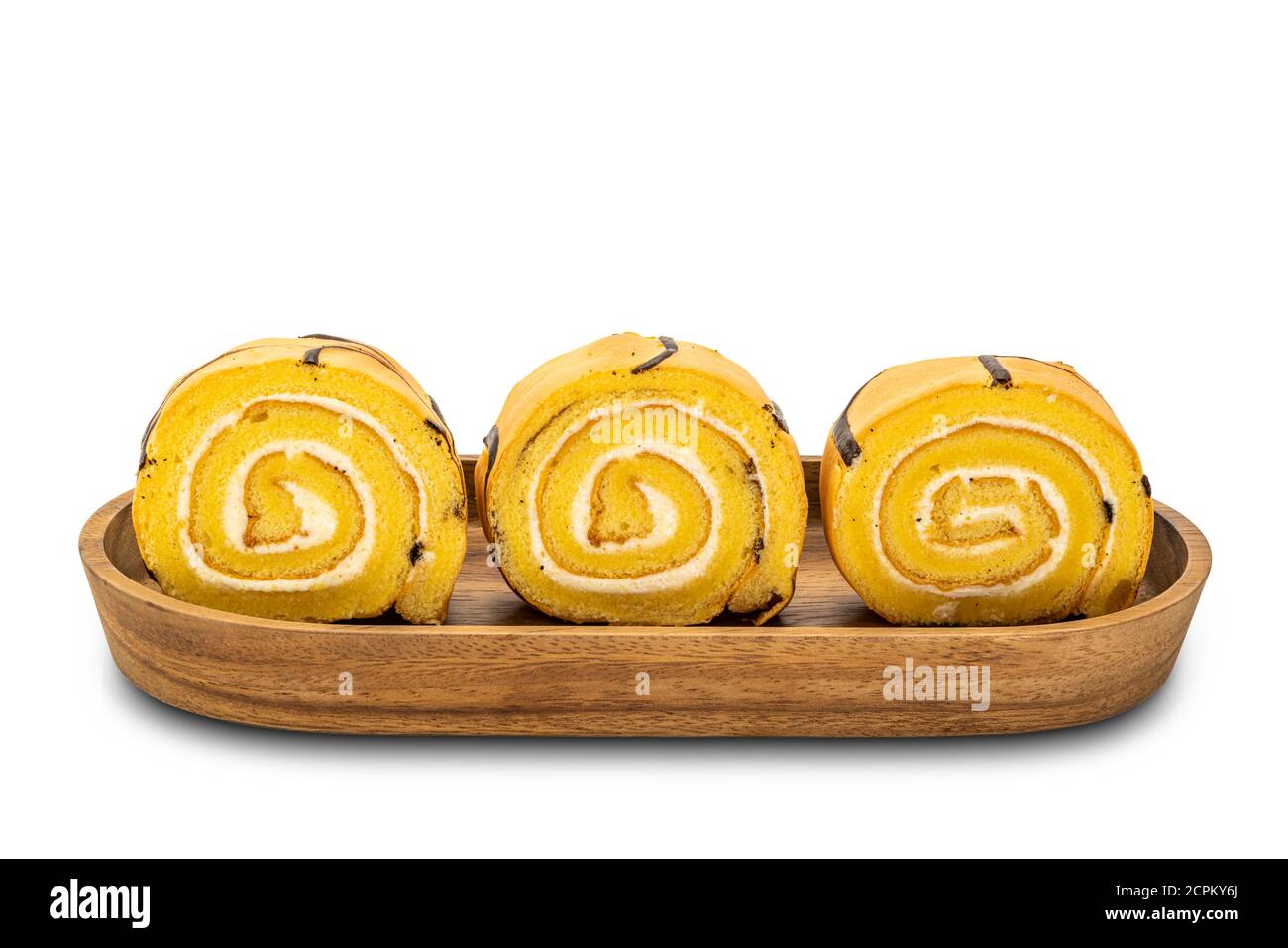 Row of sliced cake roll in a wooden tray on white background with clipping path. Stock Photo
