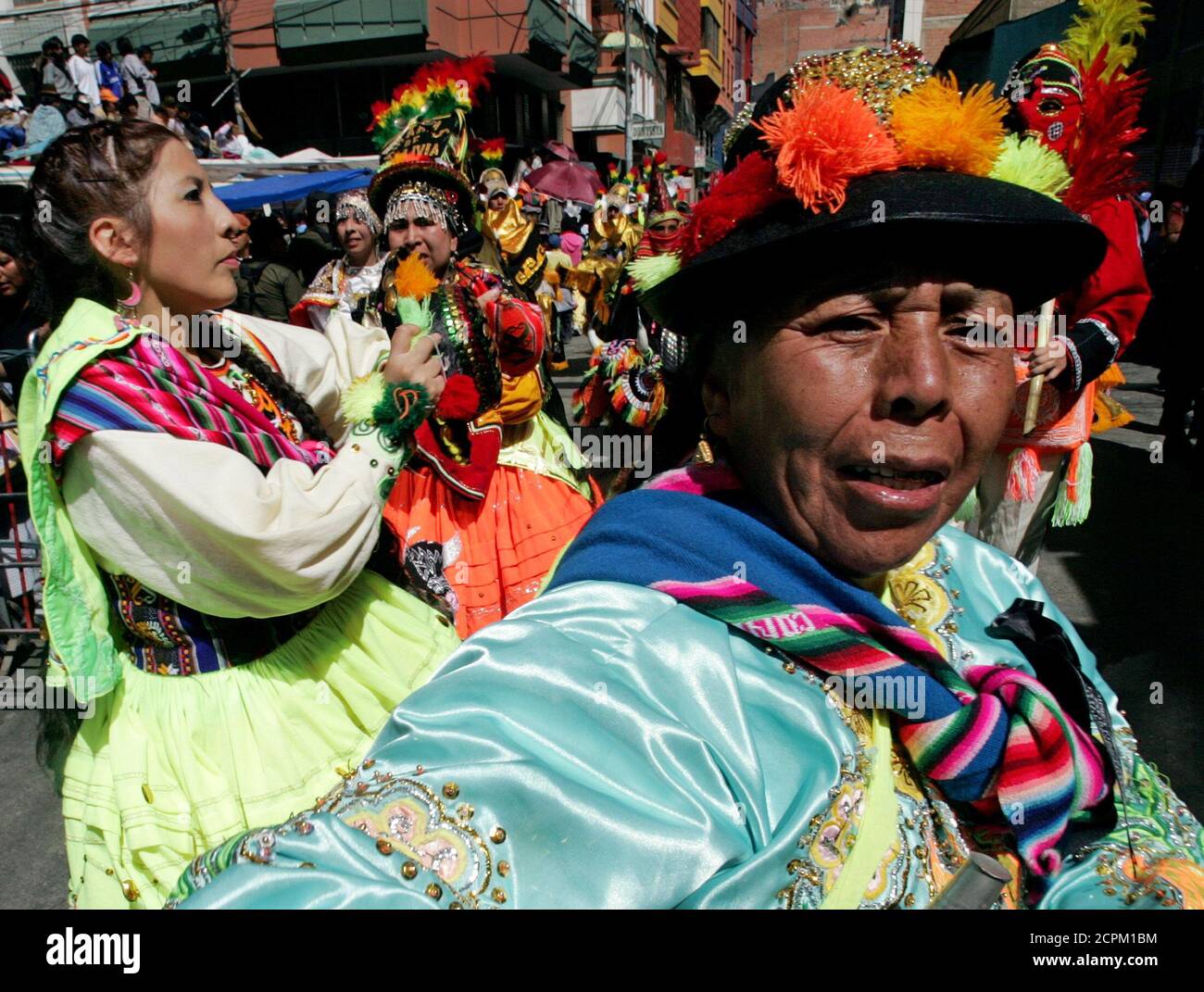 Bolivian Aymara Indian woman dance as they take part in the 'El Senor del Gran Poder' (Feast of the Great Power of Jesus) festival in La Paz, Bolivia May 21, 2005. The feast, which is one of the most important and expressive manifestations of La Paz' cultural identity, had its origins in the arrival in the Ch'ijini area of a canvas showing a three-faced figure. The image was reinterpreted according to the Aymara tradition to mean that one asked the face on the right for good things, the left for negative things, while one prayed to the center face. The Catholic Church had the canvas repainted  Stock Photo