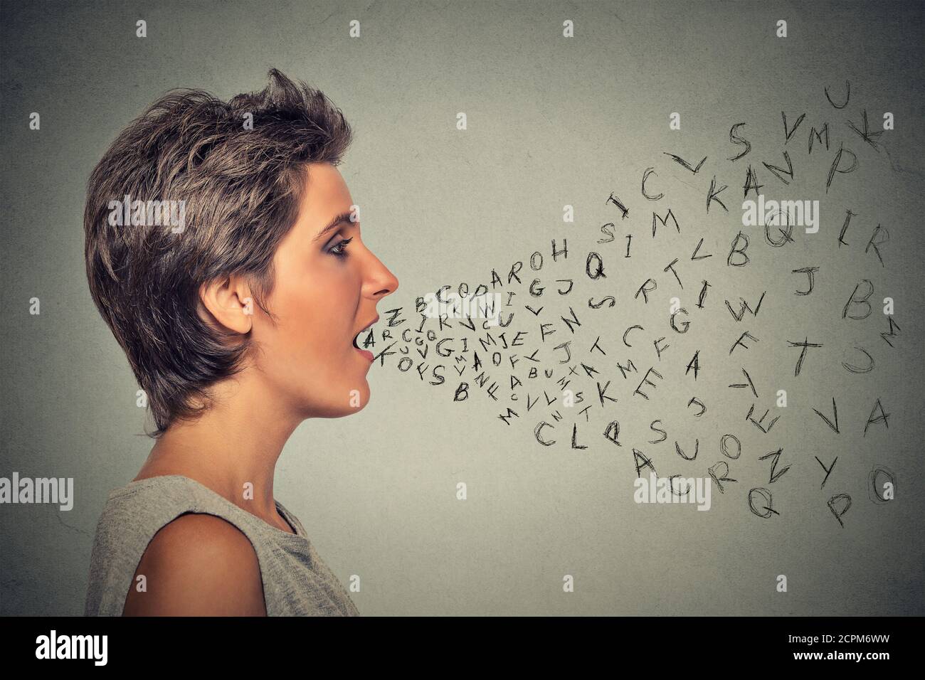 Side profile woman talking with alphabet letters coming out of her mouth. Communication, information, intelligence concept Stock Photo