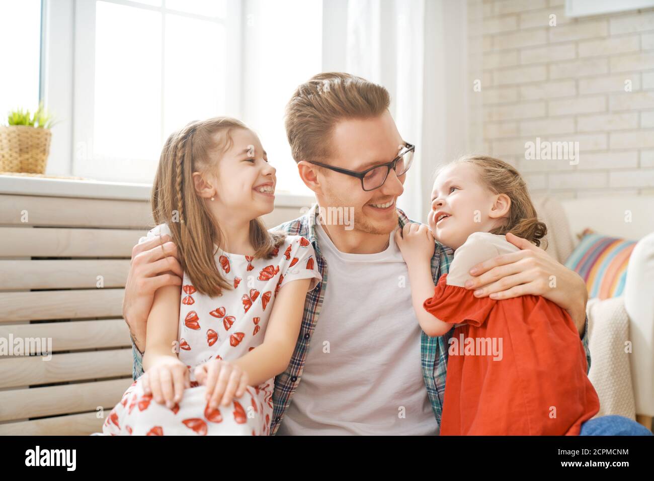 Happy loving family. Daddy and his daughters children girls playing together. Father's day concept. Stock Photo