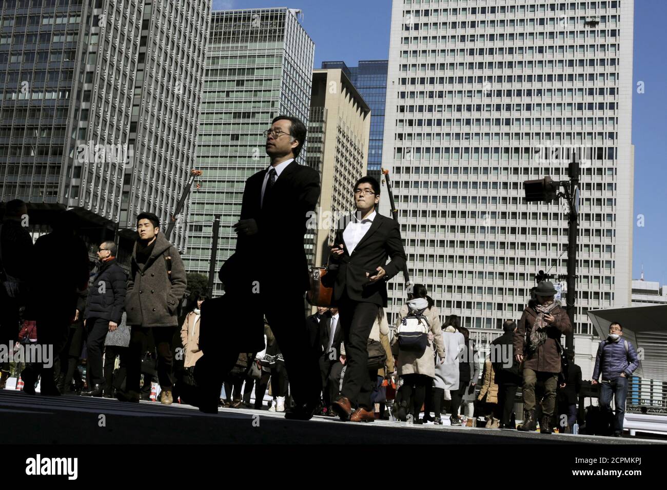 People cross a street in a business district in Tokyo, Japan, February 16, 2016. The Bank of Japan's negative interest rates came into effect on Tuesday in a radical plan already deemed a failure by financial markets, highlighting Tokyo's lack of options to spur growth as global markets sputter.  REUTERS/Thomas Peter Stock Photo