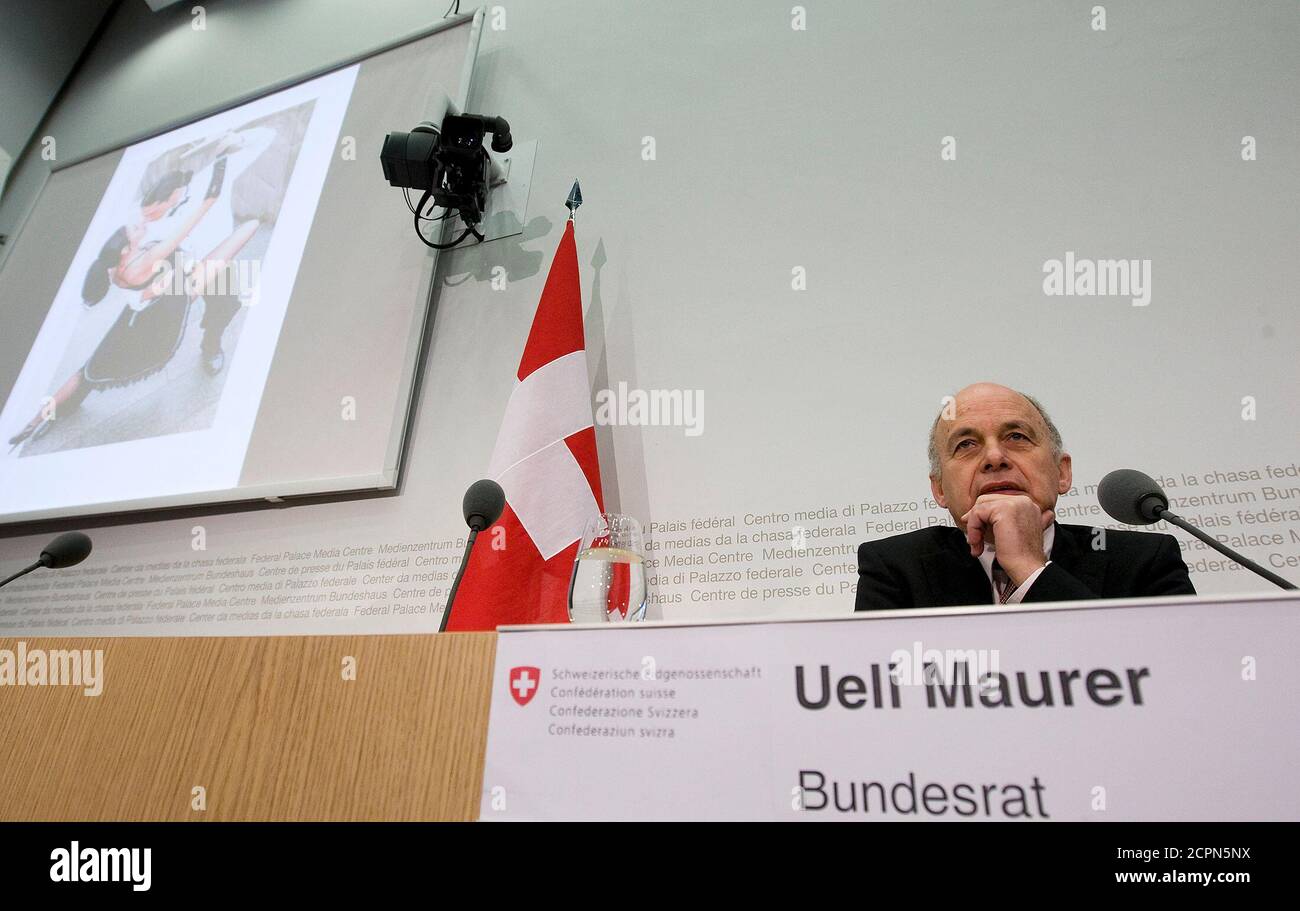 Swiss Defence and Sport Minister Ueli Maurer shows a projection of tango  dancers to illustrate passion during a news conference prior his 100th day  as Minister in Bern April 3, 2009. REUTERS/Pascal