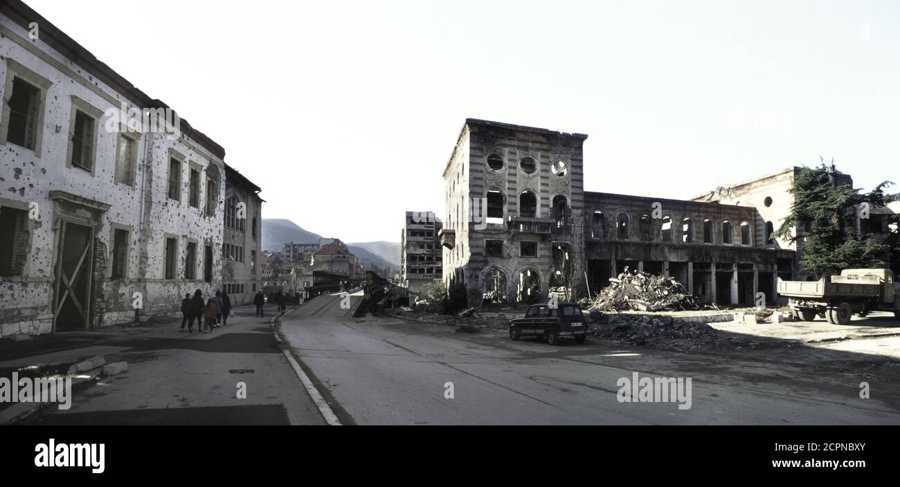 10th December 1995 During the war in Bosnia: the view west, down Mostarskog bataljona on the east (Muslim) side of the river in Mostar, towards a temporary bridge (today, the Most Musala), over the Neretva River. Stock Photo