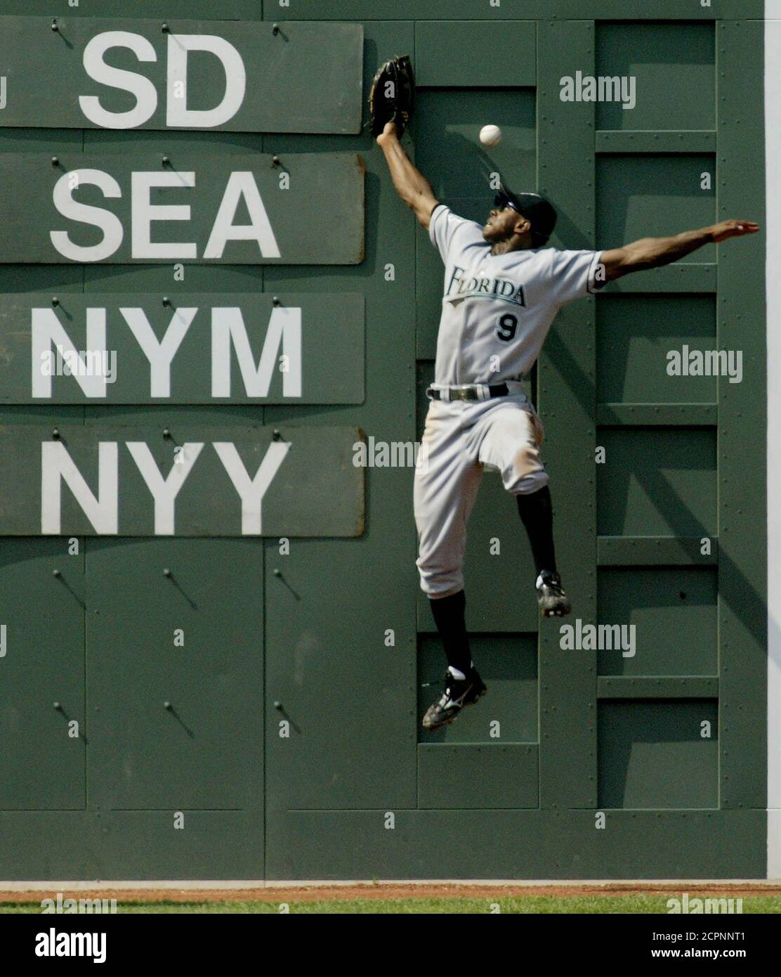 Florida Marlins' centerfielder Juan Pierre leaps for, and misses, a double off the Fenway Park 'Green Monster' scoreboard by Boston Red Sox batter Bill Mueller in the fifth inning June 29, 2003 at Fenway Park in Boston. REUTERS/Jim Bourg  JRB/GAC Stock Photo